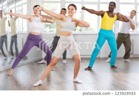 Smiling young girl enjoying vigorous dance at group class 123929583