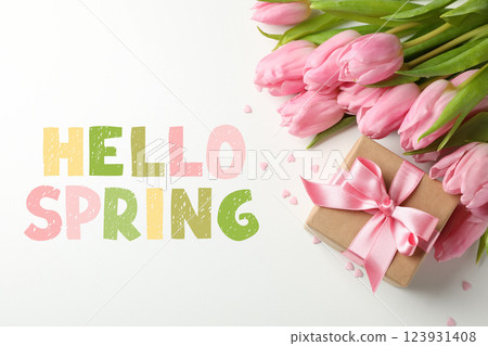 Hello spring, gift box and pink tulips on white background, top view, with text Hello spring, gift box and pink tulips on white background, top view, with text 123931408