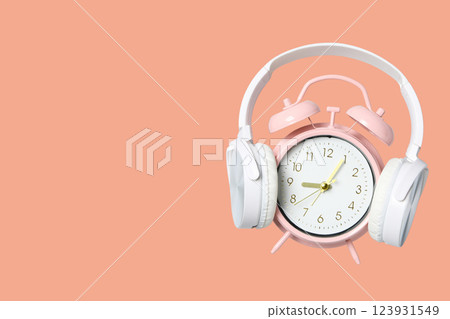 Spring Forward. Design, alarm clock with headphones, on a pink background. 123931549