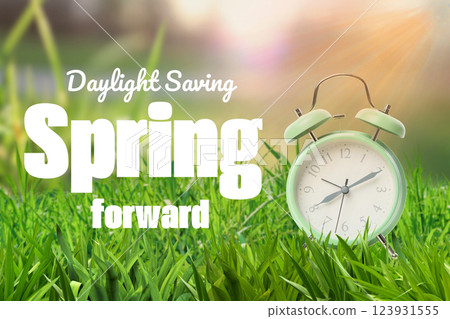 Spring Forward. Design, alarm clock with inscription on grass. 123931555