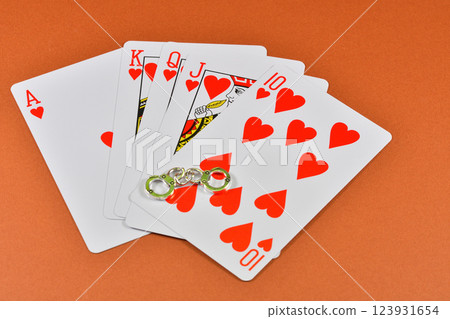 一名因非法賭博而被捕的男子手持撲克牌和手銬的圖片 一名因非法賭博而被捕的男子手持撲克牌和手銬的圖片 123931654