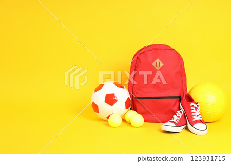 A briefcase with different balls on a yellow background A briefcase with different balls on a yellow background 123931715