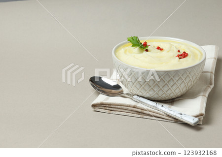 Mashed potatoes in bowl on towel and spoon on gray background, space for text Mashed potatoes in bowl on towel and spoon on gray background, space for text 123932168