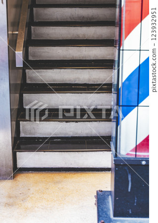 Barber shop, sign pole, flat bar, barber pole, multi-tenant building, stairs Barber shop, sign pole, flat bar, barber pole, multi-tenant building, stairs 123932951