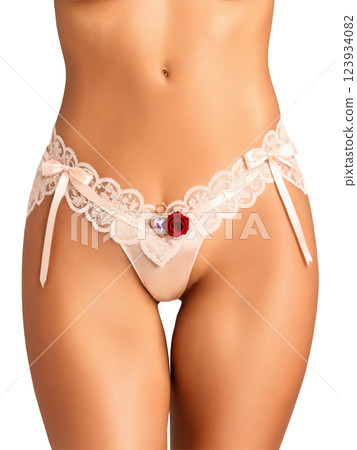 A satin silk garter with lace trim and a small heart-shaped rose quartz pendant, designed to add a personal, romantic A satin silk garter with lace trim and a small heart-shaped rose quartz pendant, designed to add a personal, romantic 123934082