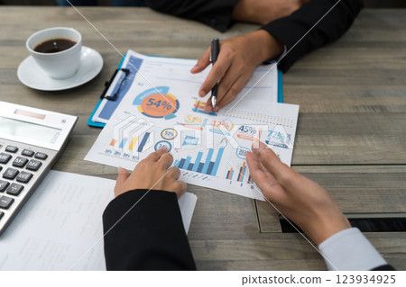 Business meeting on the desk at work. Human hands on a table with documents, graphs, charts, calculator. 123934925