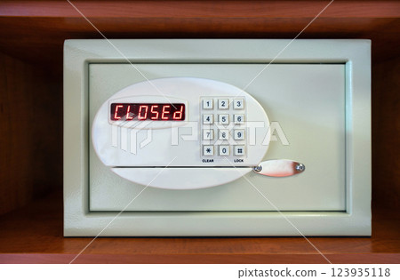 A safe with a numeric keypad show a bright red CLOSED message. The setting suggest it is designed to keep valuable secure and inaccessible. 123935118