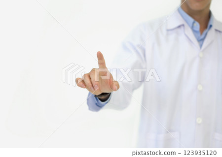 A medical professional in a white coat is pointing with one finger, demonstrating a key concept during a consultation. The background is plain and neutral. A medical professional in a white coat is pointing with one finger, demonstrating a key concept during a consultation. The background is plain and neutral. 123935120
