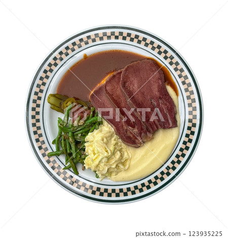 Cured beef tongue and mash menu in american diner restaurant. Topped with gravy and  mash potatoes. Green beans, pickles and a side of slaw are served on the plate. 123935225