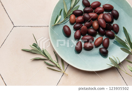 Kalamata olives with olive branches served on a modern plate 123935502