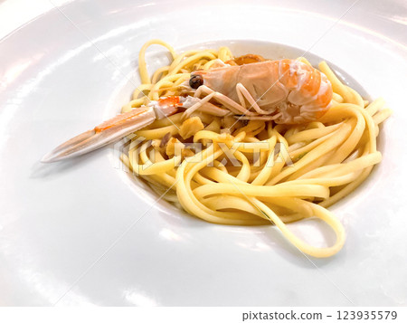 Sauteed linguine pasta with fish cream, lemon zest and roasted scampi. First course menu in international restaurant. Sauteed linguine pasta with fish cream, lemon zest and roasted scampi. First course menu in international restaurant. 123935579