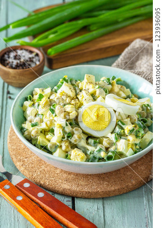 Spring salad with egg, green peas and green onions in a bowl on a rustic table. 123936095