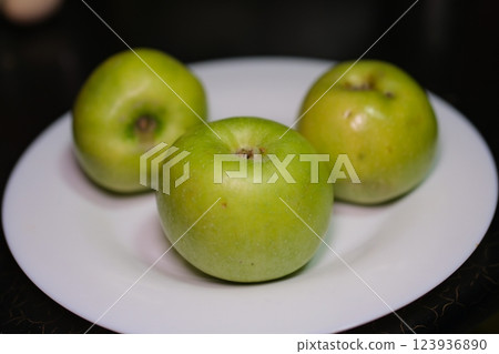 Plate with fresh green apples over green background. Flat lay with copy space Plate with fresh green apples over green background. Flat lay with copy space 123936890