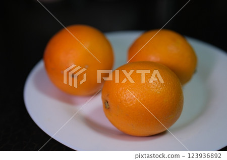 oranges on a white plate three pieces oranges on a white plate three pieces 123936892