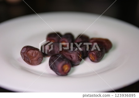 Serving date fruit, islamic holy month ramadan concept image idea caucasian woman hands holding serving date fruits. Special nutrition snack for Iftar.  123936895