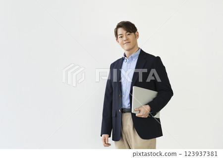 一位三十多歲的商人拿著筆記型電腦 一位三十多歲的商人拿著筆記型電腦 123937381