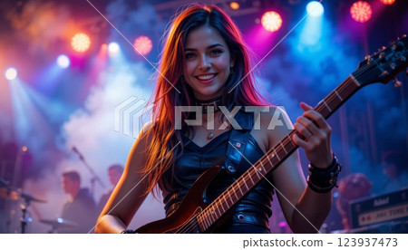 Smiling Young Female Guitarist Rocking on Stage with Colorful Lights and Smoke 123937473