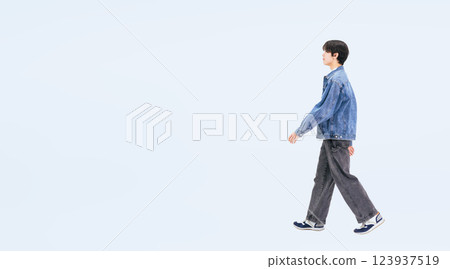 一位身著休閒裝、側身行走的年輕男子的全身照片 一位身著休閒裝、側身行走的年輕男子的全身照片 123937519