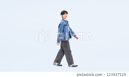 Full body photo of a young man in casual wear walking sideways 123937520