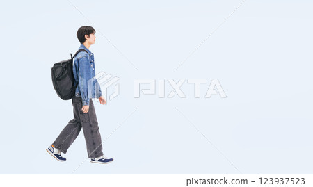 Full body photo of a young man in casual wear walking sideways 123937523