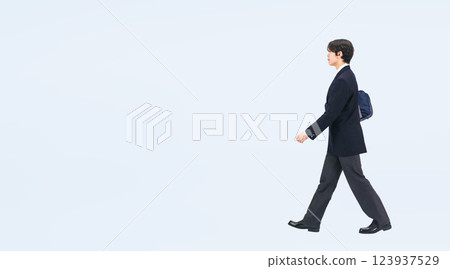 Full-body photo of a male student in uniform walking sideways 123937529