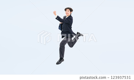 Full-body photo of a male student in uniform jumping Full-body photo of a male student in uniform jumping 123937531