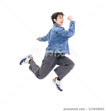 一名身著休閒服裝的年輕人正在跳躍。 123938091