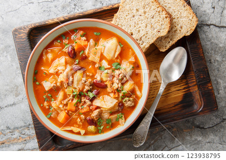 Italian sausages cabbage tomato soup with vegetables close-up in a bowl. Horizontal top view 123938795