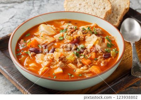 Yummy beef and cabbage soup with additional ingredients are tomato, kidney beans, carrot and celery closeup in the plate. Horizontal Yummy beef and cabbage soup with additional ingredients are tomato, kidney beans, carrot and celery closeup in the plate. Horizontal 123938802