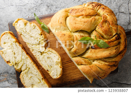 Savory braided pesto bread closeup on the wooden board. Horizontal top view 123938807