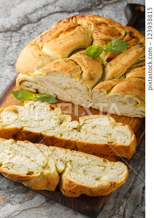 Homemade bread is braided with basil pesto closeup on the wooden board. Vertical Homemade bread is braided with basil pesto closeup on the wooden board. Vertical 123938815
