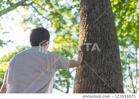 Back view of a man holding a tree 123938875