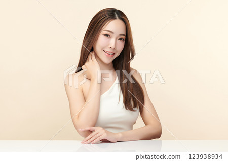 A beautiful young Asian woman with clean, fresh skin against a beige background. She represents beauty, skincare, and spa treatments. A beautiful young Asian woman with clean, fresh skin against a beige background. She represents beauty, skincare, and spa treatments. 123938934