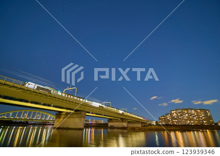 View of the winter starry sky and the Odakyu Tamagawa Bridge from the Tama River in Noborito, Tama Ward, Kawasaki City, Kanagawa Prefecture at night 123939346