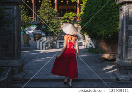 back of a young woman tourist in traditional Vietnamese hat Non La at a pagoda in Vietnam on travel to Asia 123939511