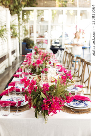 A set festive table in the open air. The table is decorated with candles and flowers 123939564