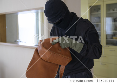 Image of a robber rummaging through a bag 123940554