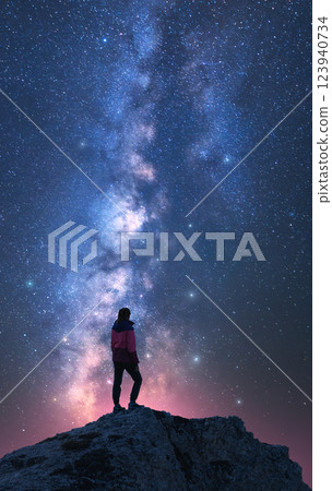 Milky Way and woman on mountain peak at starry night. Vertical Milky Way and woman on mountain peak at starry night. Vertical 123940734
