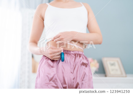 Young woman measuring waist circumference, no face 123941250