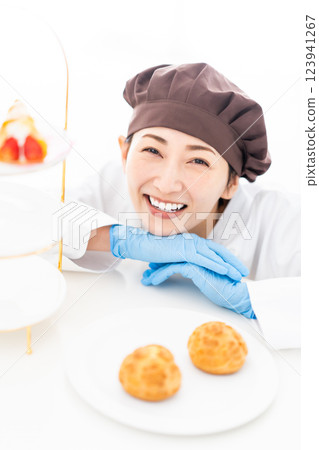 A smiling pastry chef in front of sweets A smiling pastry chef in front of sweets 123941267