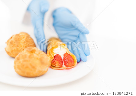 糕點師將糖果擺放在盤子上（無臉） 123941271