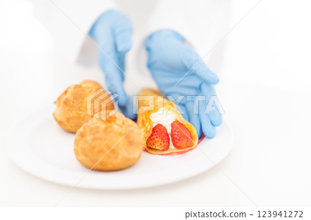 Pastry chef arranging sweets on a plate (no face) Pastry chef arranging sweets on a plate (no face) 123941272