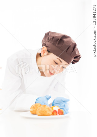 一位微笑的糕點廚師站在甜點前 一位微笑的糕點廚師站在甜點前 123941273