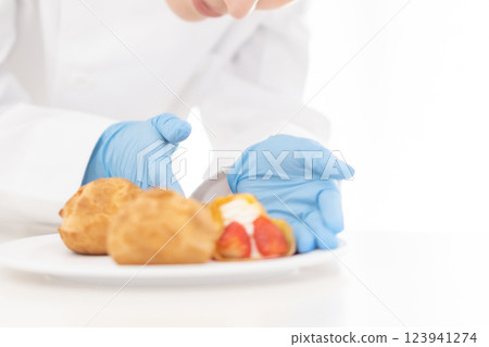 糕點師將糖果擺放在盤子上（無臉） 123941274