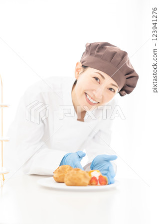 一位微笑的糕點廚師站在甜點前 123941276