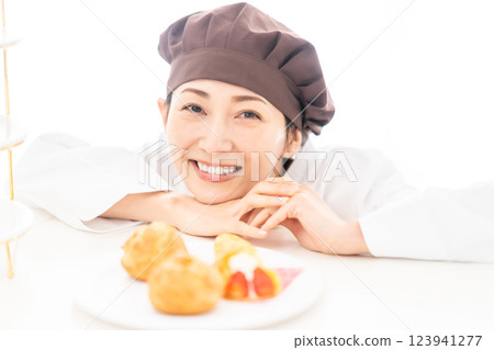 A smiling pastry chef in front of sweets A smiling pastry chef in front of sweets 123941277
