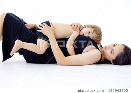 Young pregnant woman is lying on floor and playing with her son 123943560