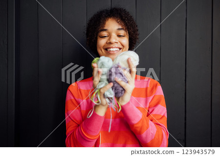 Close-up of a smiling African woman with balls of multicolored yarn. 123943579