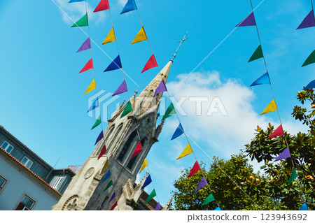 Colorful flags before an old church tower against a blue sky for summer festival in June San Juan 123943692