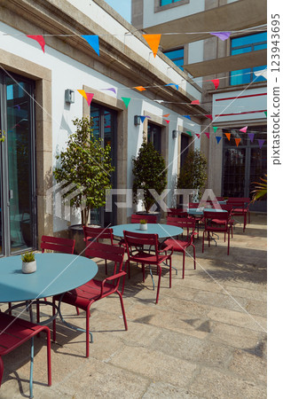 A courtyard, red chairs, and a large potted plant decorated for summer festival in June San Juan A courtyard, red chairs, and a large potted plant decorated for summer festival in June San Juan 123943695